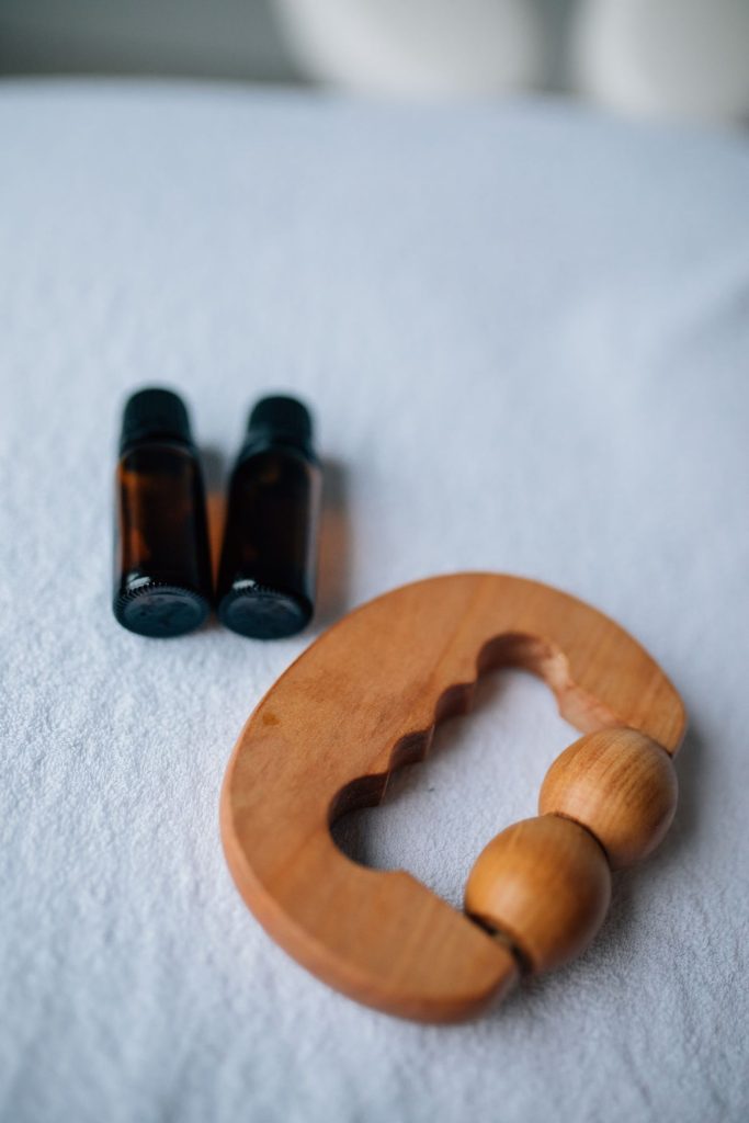 Chai tinh dầu và dụng cụ massage bằng gỗ